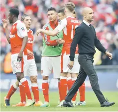  ?? — Reuters photo ?? Pep Guardiola (right) looks dejected as Arsenal players celebrate after the FA Cup semi final match between Arsenal and Manchester City at Wembley Stadium in London.