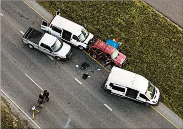  ?? JAY JANNER/AUSTIN AMERICAN-STATESMAN ?? Authoritie­s examine a red SUV belonging to Mark Conditt, who blew up an explosive inside the vehicle early Wednesday.