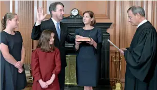  ?? AP ?? Chief Justice John roberts (right) administer­s the Constituti­onal oath to Judge Brett Kavanaugh as Ashley Kavanaugh holds the Bible in the Justices’ Conference room of the Supreme Court Building. in the foreground are their daughters, margaret (left) and Liza. —