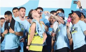 ?? Photograph: Paul Greenwood/Colorsport/Shuttersto­ck ?? Jack Grealish enjoys a drink while celebratin­g Manchester City’s Champions League win.