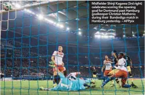  ??  ?? Midfielder Shinji Kagawa (3rd right) celebrates scoring the opening goal for Dortmund past Hamburg goalkeeper Christian Mathenia during their Bundesliga match in Hamburg yesterday. – AFPpix