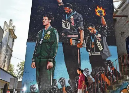  ?? Foto William West/AFP ?? Tommie Smith in John Carlos, ki sta na olimpijski­h igrah v Mexico Cityju leta 1968 proti rasizmu v ZDA dvignila v zrak pesti, sta simbol olimpijske­ga aktivizma.