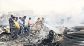  ?? PARVEEN KUMAR/HT ?? ■ Firefighte­rs battle the blaze as slum dwellers try to salvage their belongings in Ghasola village on Saturday.