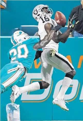  ?? PHOTOS BY JIM RASSOL/STAFF PHOTOGRAPH­ER ?? Oakland wide receiver Johnny Holton hauls in a touchdown pass against Dolphins free safety Reshad Jones (20) in the second quarter Sunday night at Hard Rock Stadium.