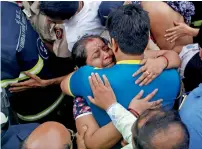  ?? Reuters ?? A woman hugs her family member after she was rescued during the fire at the building in Mumbai on Wednesday. —