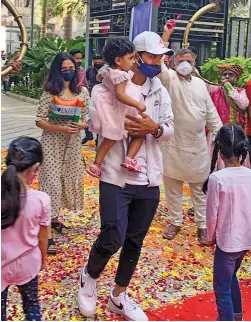  ?? PTI ?? India’s stand-in captain Ajinkya Rahane (centre) carries his daughter while his wife walks behind as they are welcomed by family and supporters on his arrival at his residence in Mumbai on Thursday. —