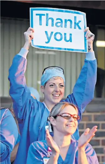  ??  ?? Clappers in credit Medical staff outside William Harvey Hospital in Ashford, Kent, join in the applause to salute local heroes during yesterday’s nationwide weekly “Clap for Carers” to recognise and support NHS and care home workers fighting the pandemic.