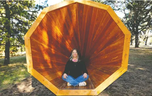  ?? LARRY WONG ?? Nora Begoray, business developmen­t director of the Edmonton Federation of Community Leagues, sits in one of the six new public art sculptures in Hawrelak Park.