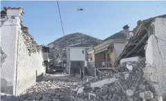  ?? AFP ?? An army helicopter flies over collapsed buildings near the town of Tyrnavos, after a strong quake hit the Greek central region of Thessaly.