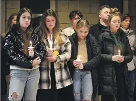  ?? Paul Sancya Associated Press ?? STUDENTS HOLD vigil at LakePoint Community Church in Oxford Township, Mich., on Tuesday for four students killed in a shooting at Oxford High School.