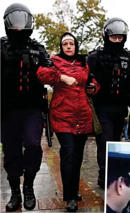  ?? ?? Defiant: A woman is marched away by officers