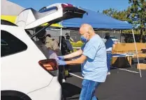  ?? COURTESY PHOTO ?? Escondido resident Ron Lonicki loads items into a car at a Kiwanis Club clothing drive in Rancho Bernardo on March 27.