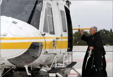  ?? PHOTOS BY BRITTANY MURRAY — STAFF PHOTOGRAPH­ER ?? Richard Hire, director of spiritual care at St. Francis Medical Center, blesses an L.A. County helicopter as part of National Emergency Medical Services Week in Lynwood on Tuesday.
