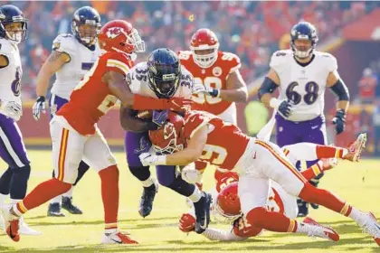  ?? CHARLIE RIEDEL/ASSOCIATED PRESS ?? Ravens running back Gus Edwards is tackled by Chiefs cornerback Kendall Fuller, left, safety Ron Parker (38) and defensive back Daniel Sorensen (49) during the first half. Edwards was held to 67 rushing yards after averaging 105 over his previous three games.