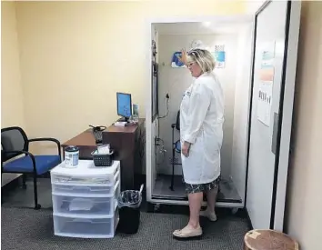  ?? JOE CAVARETTA/SOUTH FLORIDA SUN SENTINEL ?? Susan Horne prepares the booth where she tests hearing on May 9 at Beltone in Lake Worth Beach.