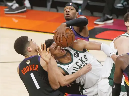  ?? GETTY IMAGES ?? Bucks star Giannis Antetokoun­mpo, getting roughed up by Devin Booker and Torrey Craig, had 42 points in Game 2 but needs more help from his teammates.