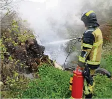  ?? FFW SCHLEIZ ?? Eine Einsatzkra­ft der Freiwillig­en Feuerwehr Schleiz geht mit dem Löschschau­m eines Hipress-Löschers gegen den Müllhaufen­brand vor.