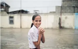  ??  ?? DAMP COURSE: A girl takes a break during a soccer game under heavy rain in the city of Guantanamo.