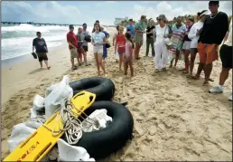  ?? J. ALBERT DIAZ/MIAMI HERALD ?? Beachgoers look at inner tubes, which were part of a raft that carried Cuban rafters to shore at Lauderdale by the Sea, Fla., on March 25, 2004. President Obama ordered an immediate end on Thursday to the long-standing U.S. policy of granting easy...