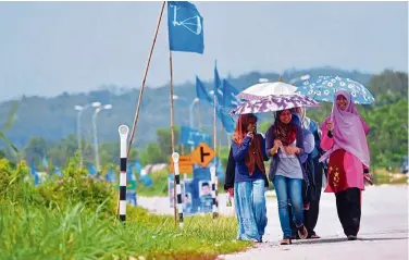  ??  ?? A file photo showing young voters going to the polling centre at SMK Dato Panglima Perang Kiri, Tapah despite the light drizzle.