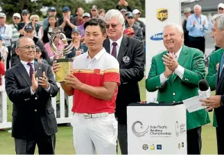  ?? MARTY MELVILLE/PHOTOSPORT ?? China’s Yuxin Lin, just 17, receives the Asia-Pacific Amateur Championsh­ip trophy and with it direct entry to the Masters and Open Championsh­ip next year.