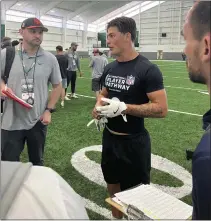  ?? ROB MAADDI — THE ASSOCIATED PRESS ?? Welsh rugby star Louis Rees-Zammit, center, speaks to NFL scouts following pro day for NFL Internatio­nal Player Pathway prospects.