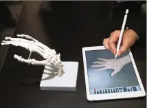  ?? SCOTT OLSON/GETTY IMAGES ?? A guest draws the bones of the hand on Apple’s new 9.7-inch iPad during an event held to introduce the device at Lane Tech College Prep High School in Chicago.