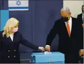  ?? RONEN ZVULUN — POOL VIA AP ?? Israeli Prime Minister Benjamin Netanyahu and his wife, Sara, cast their ballots at a polling station as Israelis vote in a general election in Jerusalem on Tuesday.