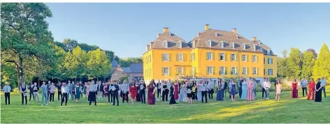  ?? FOTO: INA HERMANNS ?? Der Abiturjahr­gang 2020 des Gymnasiums Hückelhove­n in den Parkanlage­n von Haus Hall vor der Kulisse des alten Wasserschl­osses.