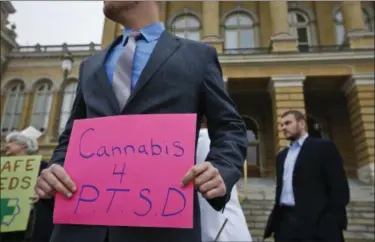  ?? MICHAEL ZAMORA — THE DES MOINES REGISTER VIA AP ?? A Marine veteran holds a sign to show support for cannabis for post traumatic stress disorder sufferers, outside the State Capitol in Des Moines, Iowa. Twenty-eight states plus the District of Columbia have enabled the use of marijuana to treat PTSD,...