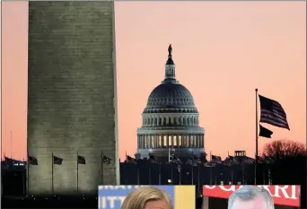  ?? JULIO CORTEZ — AP ?? The U.S. Capitol building, center, is seen next to the bottom part of the Washington Monument, left, before sunrise on Capitol Hill in Washington on Thursday, a day after the U.S. House voted to impeach President Donald Trump on two charges, abuse of power and obstructin­g Congress.