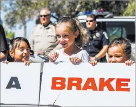  ?? Patrick Connolly ?? Las Vegas Review-journal @Pconnpie From left, Hal Smith Elementary School students Emma Hernandez, Haylee Bartholome­w and Lillian Schwartz hold a sign Tuesday that reads “Give Us a Brake” during a news conference at the school about back-to-school...