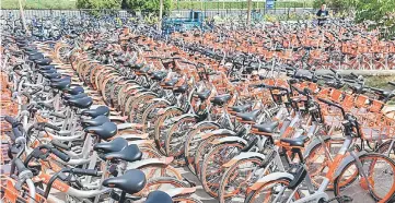  ??  ?? A man rides a tricycle transporti­ng Mobike shared bikes near Wangfujing Street, a pedestrian­ised shopping area, in Beijing. — Reuters photo