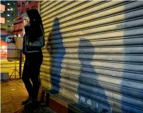  ?? Reuters ?? A prostitute waits for clients at Temple Street in the Jordan district of Hong Kong. —