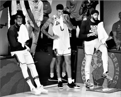  ?? AP Photo/Ashley Landis ?? Los Angeles Lakers’ LeBron James (left) Kyle Kuzma (0) and Anthony Davis (right) watch the final seconds of the fourth quarter of an NBA basketball first round playoff game against the Portland Trail Blazers on Saturday in Lake Buena Vista, Fla.