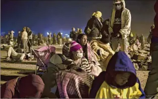  ?? ?? Migrants gather near the border wall amid heavy dust storms between the United States and Mexico in Ciudad Juárez, Mexico, on May 10.