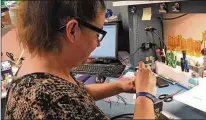  ?? THOMAS GNAU / STAFF ?? Therese English, a laser speed assembly worker, works through her NDC Technologi­es’ grand opening at its headquarte­rs Tuesday in Huber Heights. NDC makes equipment that measures the compositio­n and dimensions of goods.