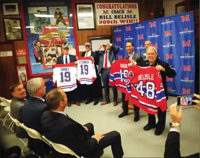  ?? Ernest A. Brown photo ?? During a morning press conference welcoming new hockey coaches at Mount Saint Charles Academy, Coaches Scott Gainey, John O’Connor, Matt Plante, Devin Rask, with Mount President Alan Tenreiro, and longtime head coach Bill Belisle, from left, are introduced in the lobby at Adelard Arena. Looking on and seated at left, are from left, Mount Saint Charles Academy Chairman of the Board of Directors Gerry Piette, and alumni Matt Jarret and Pete Belisle.