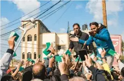  ?? MOHAMMED ABED/GETTY-AFP ?? Palestinia­ns wave identity cards as they gather to receive flour rations for their families outside a warehouse of UNRWA, the United Nations agency that aids Palestinia­ns, in Rafah in the southern Gaza Strip on Tuesday.