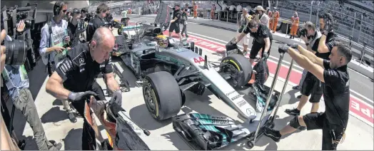  ??  ?? PIT STOP: Mercedes driver Lewis Hamilton is attended to by his team’s pit crew during yesterday’s Russian Grand Prix practice session at the Sochi Autodrom Circuit.