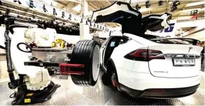  ?? FABIAN BIMMER/REUTERS ?? teaser. FUTURISTIS: Robot mengganti ban Tesla dalam Hannover Fair, Jerman, 24 April lalu. Tesla bakal meluncurka­n truk listrik.