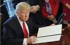 ?? PABLO MARTINEZ MONSIVAIS, THE ASSOCIATED PRESS ?? Donald Trump signs order to review the Dodd-Frank financial oversight law.