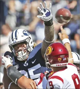  ?? AP PHOTO/GEORGE FREY ?? BYU defensive lineman Khyiris Tonga (95) tries to knock down a pass from Southern California quarterbac­k Kedon Slovis (9) in the first half of an NCAA college football game, on Saturday, in Provo, Utah.