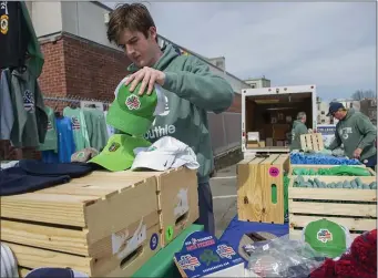  ?? AMANDA SABGA — BOSTON HERALD ?? Nolan Doherty of Dorchester organizes hats at a pop-up shop by Southie Apparel on East Broadway as the city braces for a fun weekend.