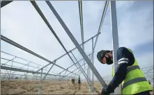  ?? ZHANG HONGXIANG / XINHUA ?? Technician­s install solar energy equipment in Qinghai province.