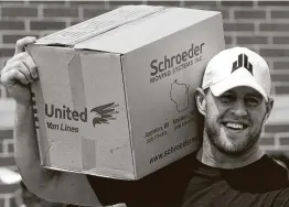  ??  ?? Watt gets ready to hand out a box of relief supplies to people who were impacted by Hurricane Harvey in 2017. His foundation raised over $41 million for relief efforts.