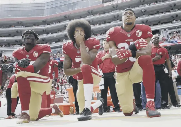  ??  ?? 0 Colin Kaepernick, centre, was one of the first to kneel during the national anthem in protest against US police shootings, a move which prompted ire from Donald Trump