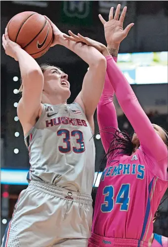  ?? JESSICA HILL/AP PHOTO ?? UConn’s Katie Lou Samuelson, left, is fouled by Memphis’ Ashia Jones during the first half of Wednesday night’s AAC game at the XL Center in Hartford. Samuelson scored 32 points, including eight 3-pointers, as the No. 3 Huskies cruised to a 102-45 victory over the Tigers.