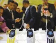  ?? (Paul Hanna/Reuters) ?? ATTENDEES EXAMINE Nokia 3310 cellphones at the Mobile World Congress in Barcelona yesterday.