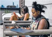  ?? DESIREE RIOS/THE NEW YORK TIMES ?? Sierra Reed, right, reads on her roof in Brooklyn, New York, with friend Sammie Nunziata.